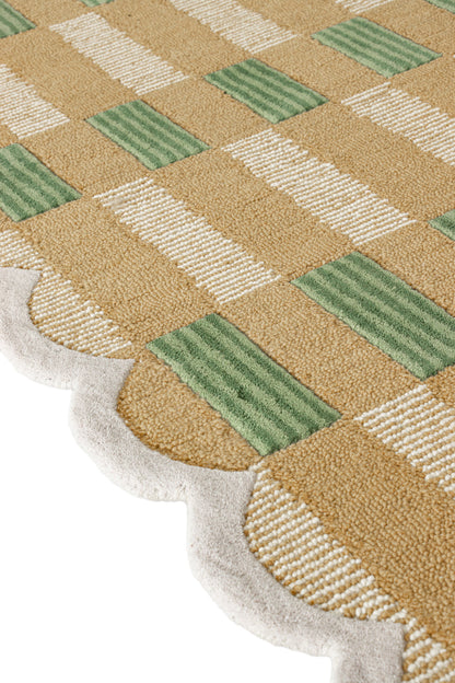 Close-up of a checkered patterned rug with green and beige colors.